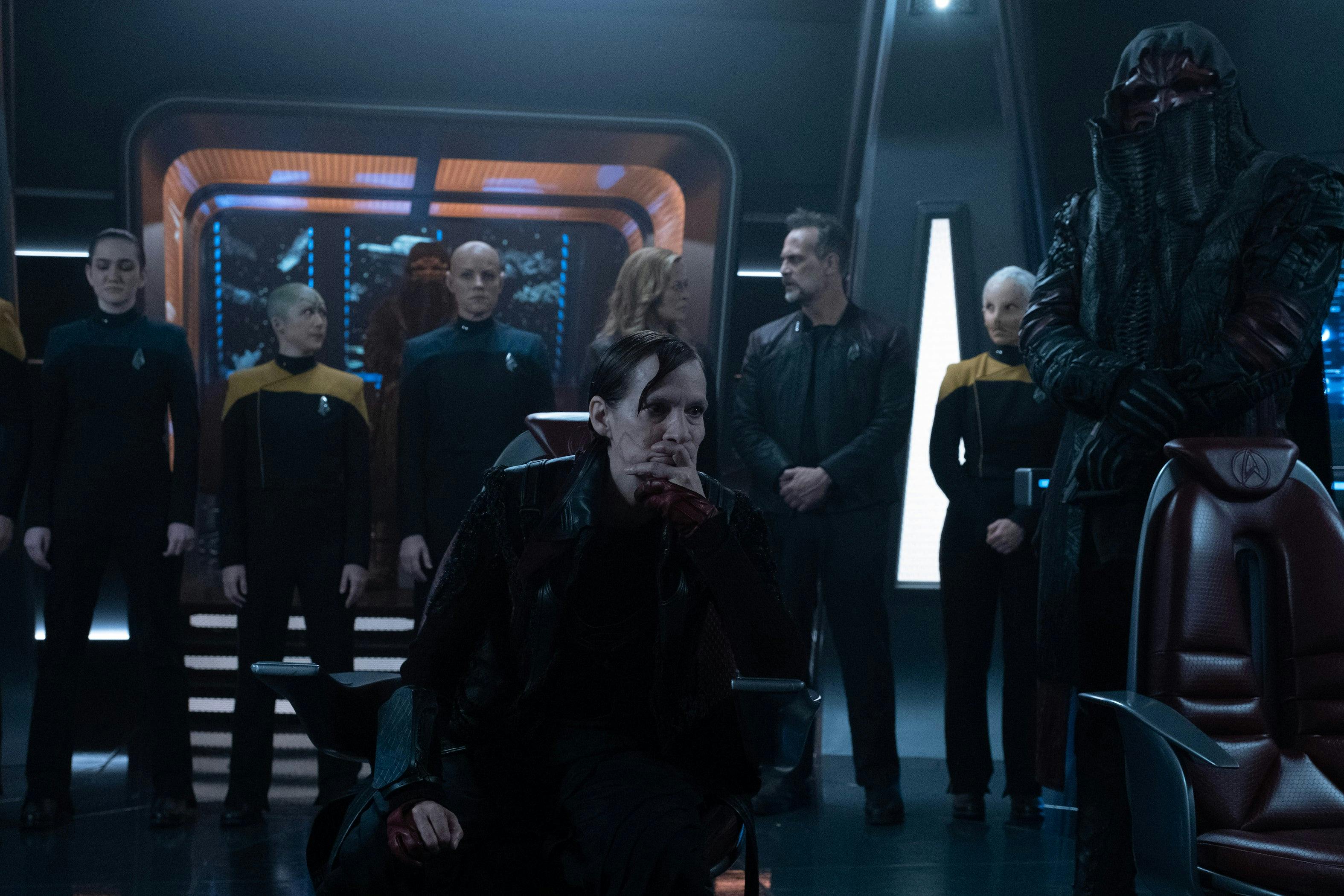 Vadic sits on the captain's chair as the captured Titan's crew stands in a line directly behind her in 'Surrender'